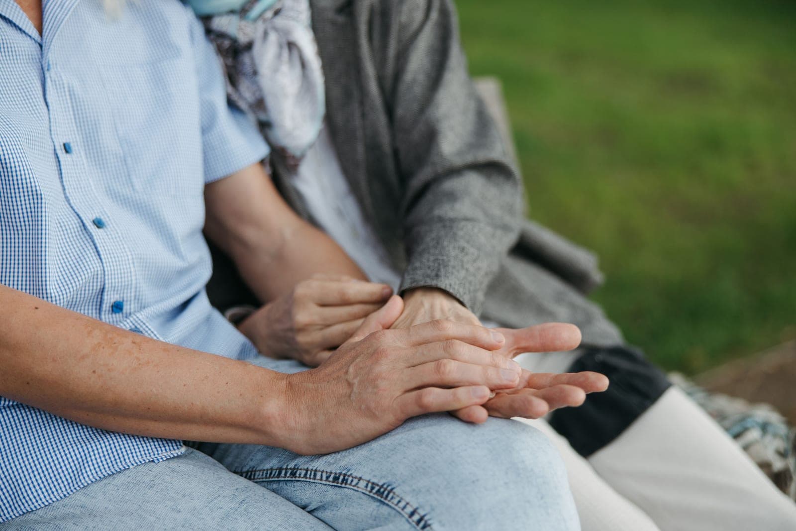 An older woman’s hands held in her daughter’s.